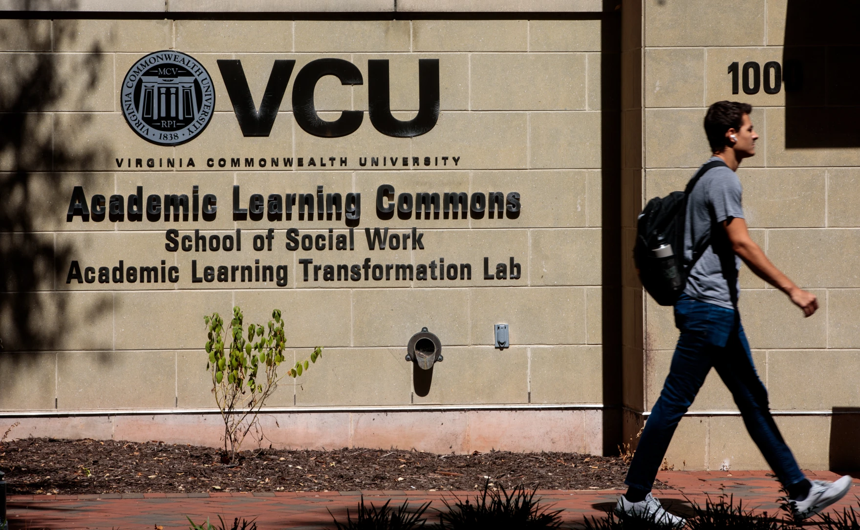 A student walks past the VCU Academic Learning Commons, which houses the School of Social Work and the Academic Learning Transformation Lab.